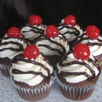 Sundae Cupcakes Cupcakes made to look like a scoop of chocolate ice cream with whip cream, fudge, and a cherry.