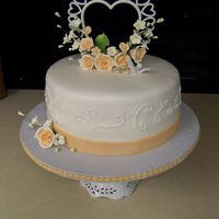 Gumpaste Peach Small wedding cake. Buttercream icing and gumpaste flowers.