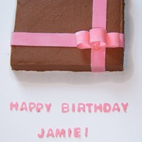 Present yellow cake with chocolate buttercream, fondant ribbon and bow