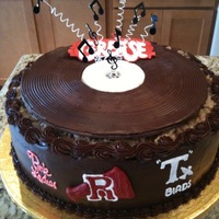 Grease Theme Cake German chocolate cake frosted in ganache. Record was made by lining a round pan with plastic wrap and then pouring wilton chocolate into it...