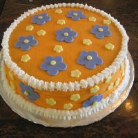 Orange Cake With Purple Flowers This cake is a strawberrt cake with strawberrt filing. Flowers were made with fondant.