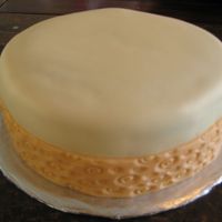 Fondant Cake This cake is a very simple cake, not to much decorated but with a nice Ivory Color and a in the bottom an orange ribbon.