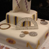 University Graduation Cake A cake made for a mechanical engineering graduate. The cake is board is covered with graph paperembellished with colored pencil and...