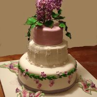 60Th Anniversary 60th anniversary cake. Lilliac gumpaste flowers and leaves, fondant decorations. Leaves onthe cake board are gumpaste.