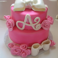 Pretty In Pink 2 tired cake with gumpaste bows and pink roses.