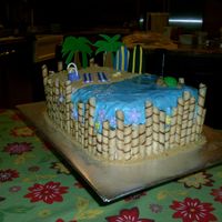 Luau Cake Buttercream with fondant accents, graham crackers for sand and a touch of piping gel for the water.