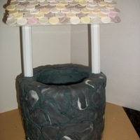 Wishing Well A dsiplay cake that was made a fund raiser. The bottom is frosted in buttercream with fondant stones/accents. The poles are cake columns....