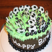 Soccer-Themed Birthday Cake My oldest son helped make his own birthday cake. It was a soccer theme. It is vanilla cake covered in chocolate buttercream frosting with...