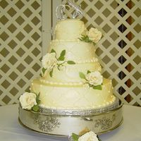 Buttercream Wedding Cake With Gumpaste Roses This is a 4 layer ivory buttercream wedding cake. 2 layers had a quilting design while the other 2 layers had a scrollwork design. The cake...