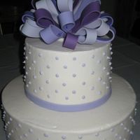Purple Anniversary Cake Buttercream icing with a multi-colored fondant bow.
