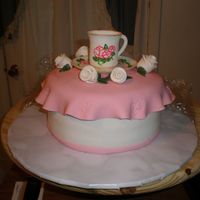 Tea Cup Cake White WASC filled & iced w/BC & covered w/SI. Tea cup, saucer & flowers made from gumpaste. Tea cup & saucer are hand-...