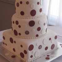 Polka Dot Cake 10" square with 8" and 6" rounds covered in fondant. Polka dots are cinnamon-colored and white fondant. Border is made with...