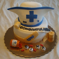 Nurses Hat Graduation carved 6 inch top tier gum paste for front of hat, fondant covered, edible images of school logos.