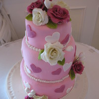Hearts And Flowers Wedding Cake Three tiered round wedding cake with gumpaste roses and doodads? I am not sue what else to call the little additions to the cake. The bride...