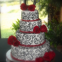 Taylor 4 tier white cake with buttercream icing covered in fondant. Scrollwork is done in royal icing. Fresh red roses. TYFL.
