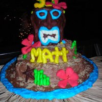 Tiki Birthday Cake 30th birthday cake, buttercream and modeling chocolate. Large Tiki head made from layered cake covered completely in modeling chocolate....