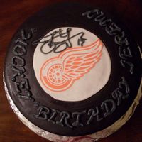 Hockey Birthday This cake is a 10" vanilla cake with buttercream and MMF. The redwing is made with edible paper.