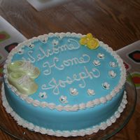 Baby Joe's Cake WASC cake with choc pudding filling. Blue fondant with gumpaste booties, and flowers accented with luster dust.