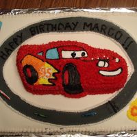 Lightning Mcqueen Birthday Cake 2 sheet cakes covered in fondant, Cars shaped pan cake on top. Black and white checker is piped stars (spray mist didn't work for me...