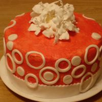 Red & White Circles W/lillies white circles on a red cake with edible lilly bouquet. Yellow Cake with vanilla buttercream.