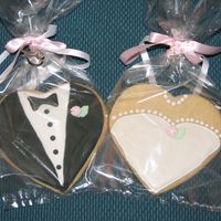 Bride & Groom Coookies heart shape sugar cookies w/Antonia74 icing and fondant flower/leaf. Next time I will use smaller heart cookie cutter and photographe...
