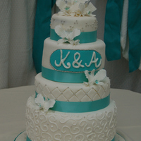 White & Aqua Alternate layers of chocolate and vanilla cake with vanilla buttercream. Handmade gumpaste lilies.