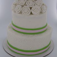 Simple Two Tier Wedding Cake This is a fondant covered two tier wedding cake. The green and pink ribbon is made from fondant. There is pink and white scroll work on the...
