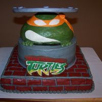 Teenage Mutant Ninja Turtle the bottom layer is cake, the sewer drain is cake, turtle head is Rice Crispy Treats, and the manhole cover is fondant-covered cardboard....