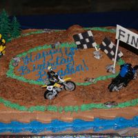 Dirt Bike Cake Dirt bike cake with fondant flags, rocks and finish sign.I used cocoa pebbles for the dirt bike path.