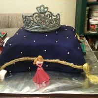 Pillow And Tiara Chocolate and Vanilla cake, covered in fondant and airbrushed purple with gold trimmings. THe crown is Royal Icing covered in luster dust...