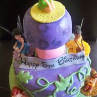 Berzayda's Fairies Tinkerbell theme. Rainbowlicious cake covered in MMF, Rice Krispie mushroom covered in MMF, edible image banners.