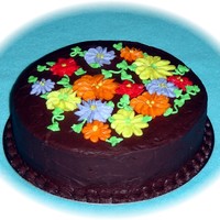 Fall Colors A white cake with raspberry filling, covered with chocolate fudge buttercream icing. Flowers are made from buttercream. Thanks for looking...