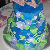 Little Girl's First Birthday Flowers And Butterflies Two tiered yellow and chocolate cake with buttercream frosting, fondant flowers and leaves, white chocolate butterflies.