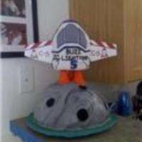 Bus Lightyear Cake With Some Personal Touches =) Moon is vanilla with butter cream and ship is chocolate with chocolate icing. Wings are craft foam. Ship is held up by Plastic dowels and...