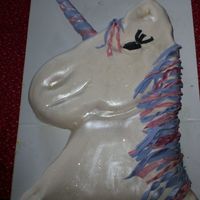 Unicorn carved from sheet cake and covered in fondant, the horn is made from gumpaste
