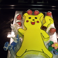 Pikachu/pokemon square and round cakes cut to shape. coverd in frosting. 3 figurines. made out of fondant/gumpaste mix. pokemon balls are cake balls (white...