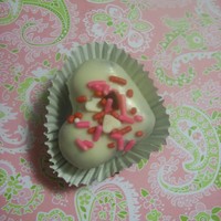Valentine Cake Truffles Heart shaped cake truffles made with red velvet cake, white chocolate BC, and covered in white chocolate with Valentine's sprinkles.