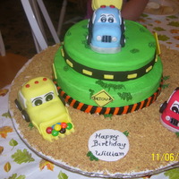 Under Construction This is a cake that I made for a 2nd birthday. The trucks are made of chocolate RTK with buttercream accents and fondant signs. Graham...