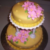 Picture_010.jpg My first tiered cake. Yellow cake with pinneapple filling, covered with yellow fondant. Lily flowers are in RI.