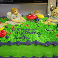 Fairy Cake My first Fairy cake, the fairies, mushrooms and elf are all fondant. I used butter cream for the rest of the cake.