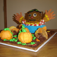 Scarecrow In Pumpkin Patch Scarecrow made in standup bear pan. BC and MMF. Pumpkins made in mini ball pan covered with MMF. Turkeys are cookies and icing.
