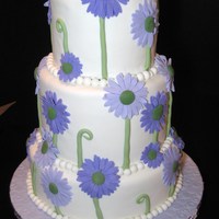 Teacher Appreciation Cake Three tier fondant covered vanilla cake with strawberry buttercream. Embellished with purple fondant daisies. I've seen seen this cake...