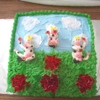 Happy Birthday Cows yellow cake with buttercream icing, rolled buttercream figures, and gelatin carnation flowers. all edible.