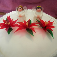 Mery Christmas Cake yellow cake with buttercream icing, rolled buttercream angels with gelatin wings. gelatin flowers. all edible.