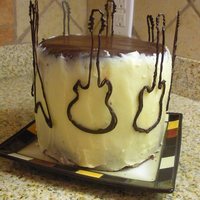 Guitar Cake A triple layer, dark chocolate whiskey cake sandwiched with a whiskey ganache, brushed with a whiskey syrup, and covered in a swiss...