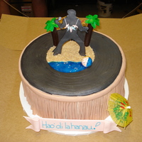 Elvis/luau 70Th Birthday Pineapple cake w/bavarian cream & pineapple filling. All decorations are fondant (except umbrellas) and writing is Hawaiian for Happy...