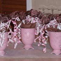 Cake Balls Cake balls and marshmallows on a stick dipped in chocolate and decorated with pink chocolate. Stuffed in cups with tissue paper.