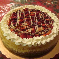 Cheese Cake and the top the cheese cake with strawberries slices with chocolate.