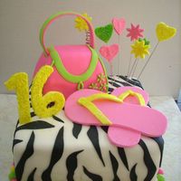 Sweet Sixteen Square Cake covered in MMF and covered with Zebra stripes out of black fondant. Purse was cut out of two 6" cakes and covered with...