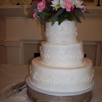 Scrolls And Pearls WASC rasberry filling, scrolls and pearls. live flowers as topper.Cake is not crooked, its the picture taker LOL